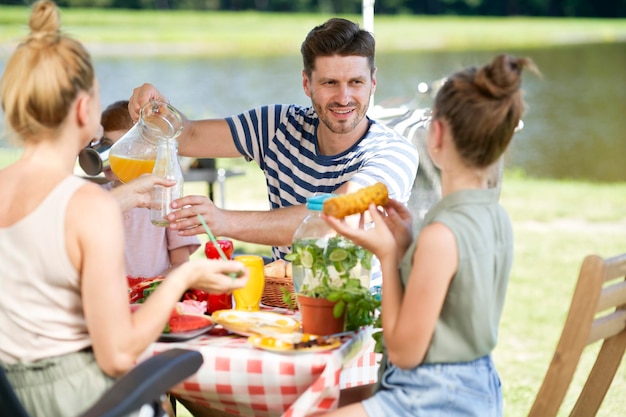 Famiglia allegra che pranza in campeggio