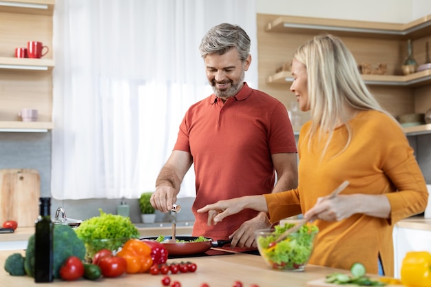 Famiglia allegra che si diverte a cucinare insieme a casa