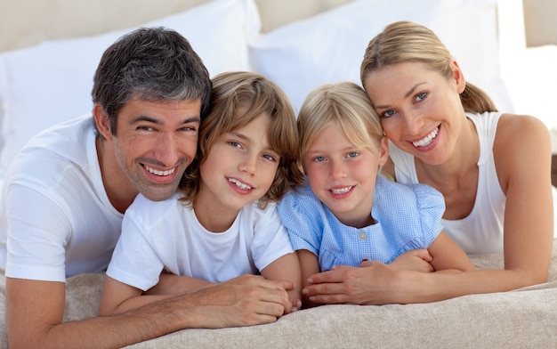 Famiglia allegra che si diverte in camera da letto