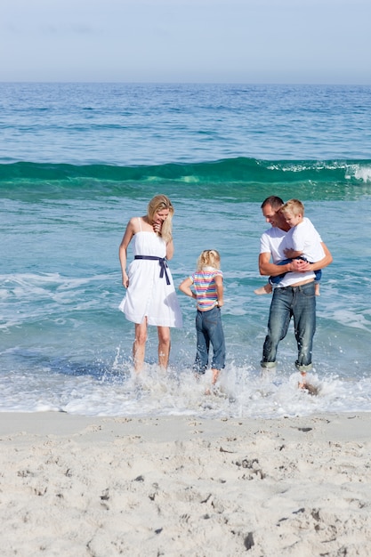 Famiglia allegra che si diverte in spiaggia