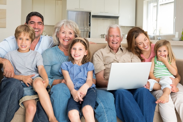 Famiglia allegra con il computer portatile in salotto