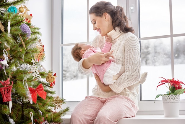 Famiglia allegra felice Madre e bambino che si abbracciano vicino alla finestra