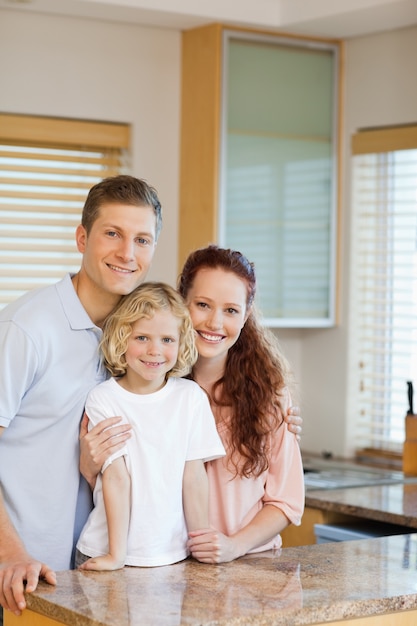 Famiglia allegra in piedi dietro il bancone della cucina