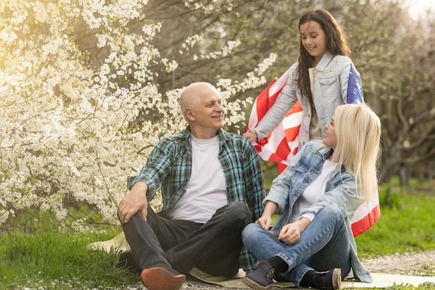 Famiglia americana con bandiera USA all'aperto.