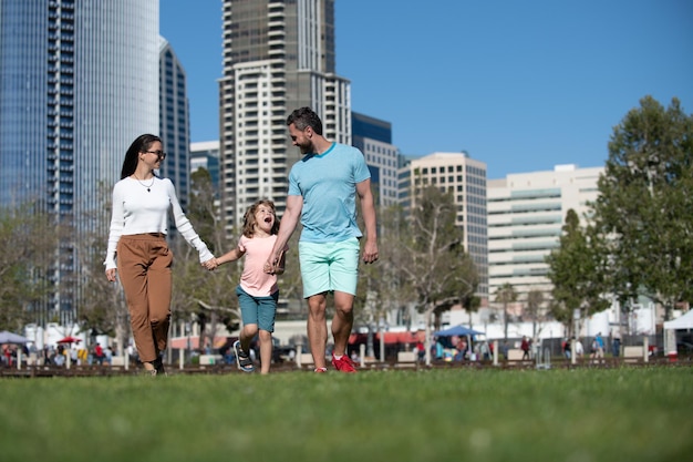 Famiglia americana felice con il figlio piccolo che cammina nella città urbana moderna