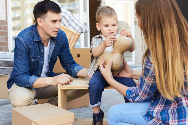 Famiglia amorosa che disimballa le scatole all'aperto