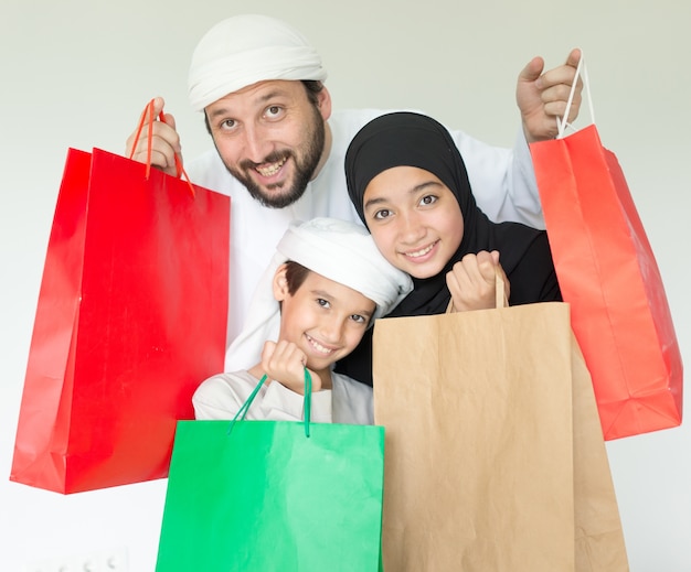 Famiglia araba felice divertendosi tempo con i sacchetti della spesa