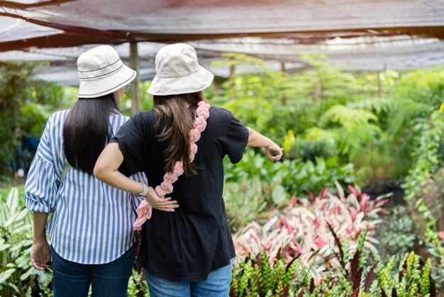 Famiglia asiatica adulta felice che sceglie e compra piante insieme al negozio di piante