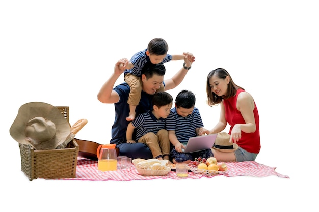 Famiglia asiatica che fa un picnic con un computer portatile