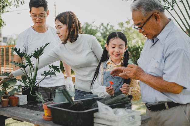 Famiglia asiatica che pianta albero in giardino a casa Genitore con stile di vita del bambino e del nonno.