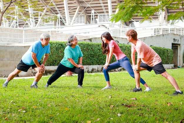 Famiglia asiatica che si esercita all'aperto al mattino Sorridono felicemente