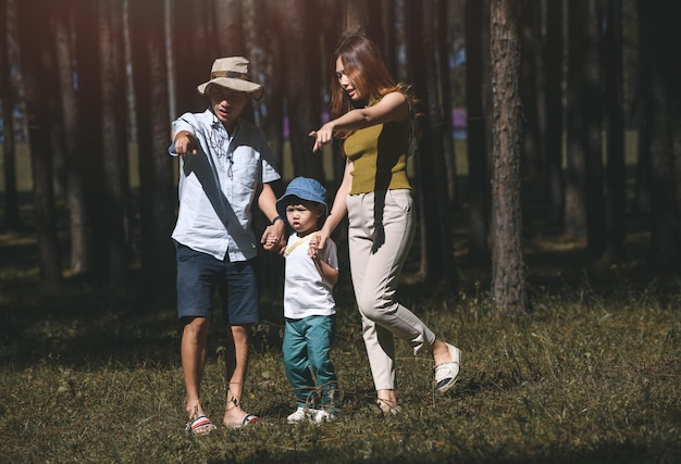 Famiglia asiatica, genitore e figlio nel giardino naturale con illuminazione solare.