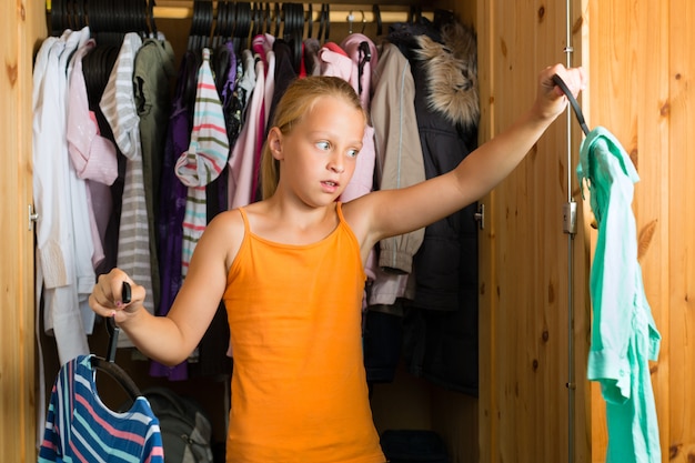 Famiglia, bambino davanti al suo armadio o guardaroba