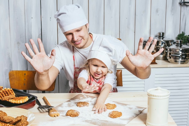 Famiglia, bella figlia papà a casa la cucina ridendo e preparando il cibo insieme