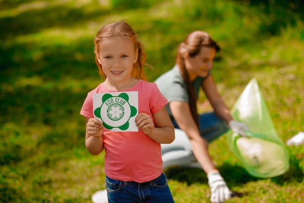 Famiglia carina che lavora in un parco che raccoglie immondizia