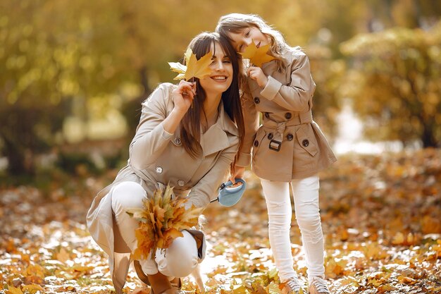 Famiglia carina e elegante in un parco autunnale