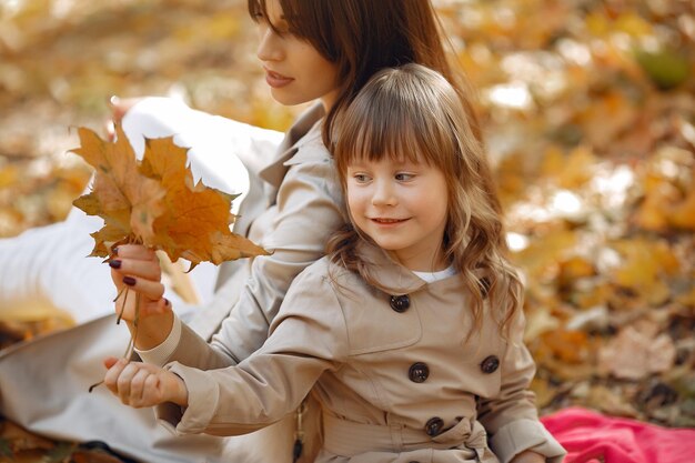 Famiglia carina e elegante in un parco autunnale