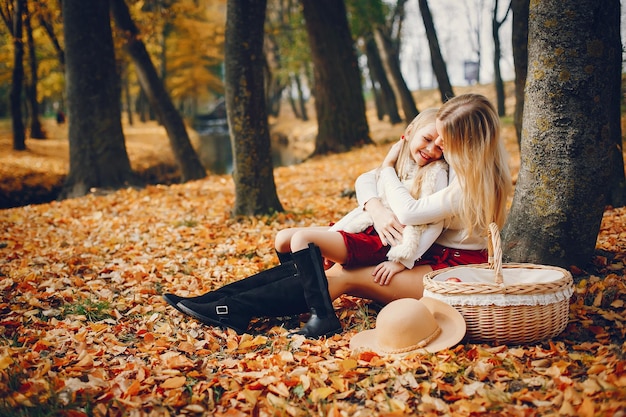 Famiglia carina e elegante in un parco autunnale