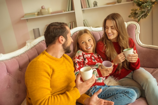 Famiglia carina seduta sul divano e sentirsi bene