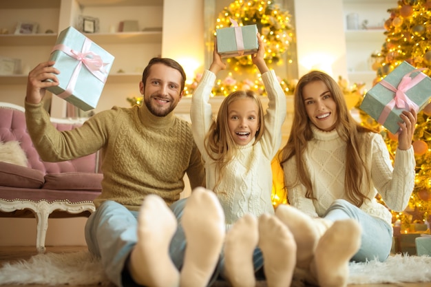 Famiglia carina seduta sul pavimento e sensazione di festa