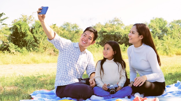 Famiglia caucasica asiatica che prende selfie con i genitori padre madre figlia