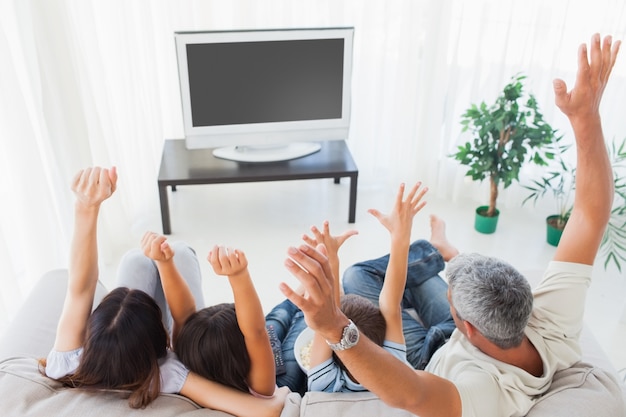 Famiglia che alza le braccia davanti alla televisione