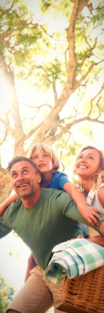 Famiglia che arriva nel parco per un picnic in una giornata di sole