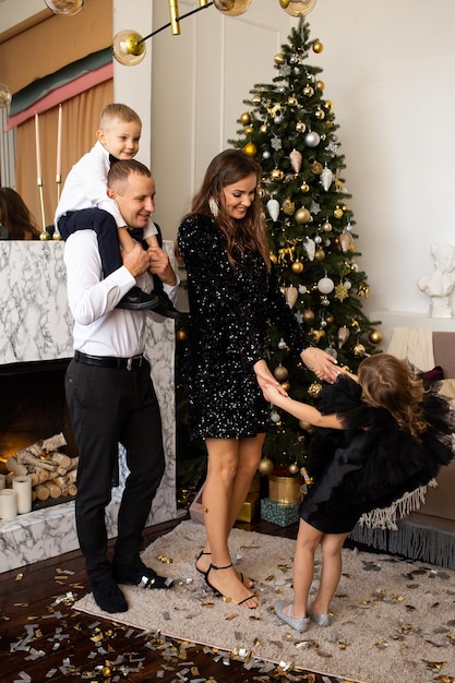 Famiglia che aspetta il Natale a casa Genitori e figli decorano l'albero di Natale in casa