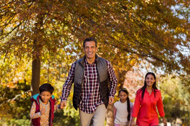 Famiglia che cammina al parco durante l'autunno