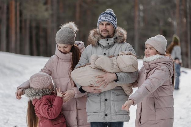 Famiglia che cammina attraverso la foresta d'inverno