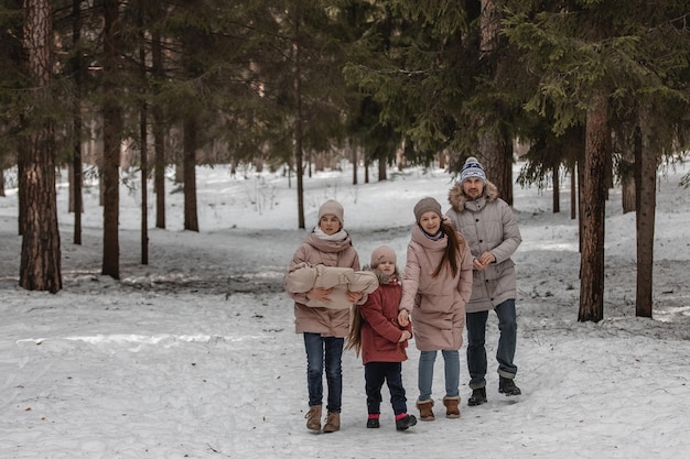 Famiglia che cammina attraverso la foresta d'inverno