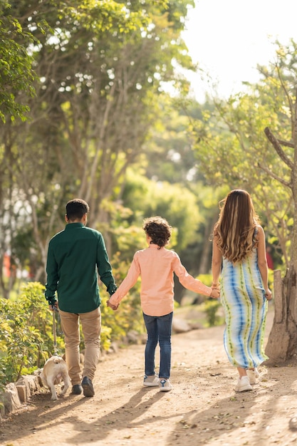Famiglia che cammina insieme lungo un parco