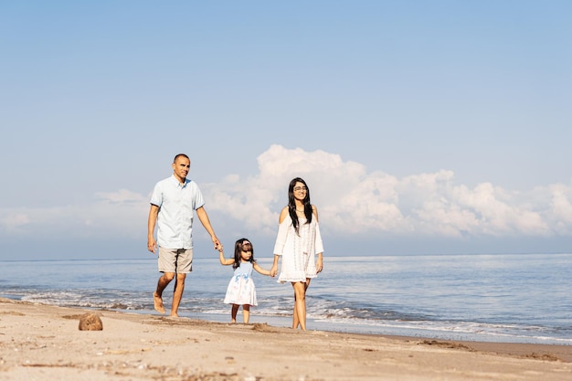 Famiglia che cammina insieme sulla spiaggia