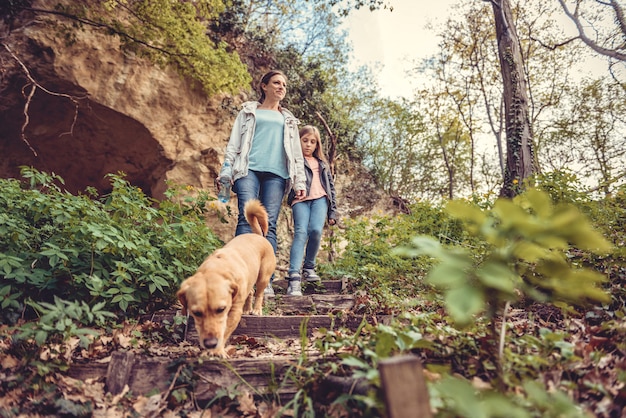 Famiglia che cammina nella foresta con un cane