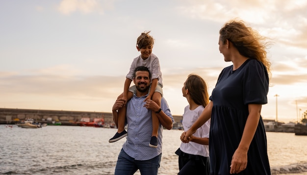 famiglia che cammina sulla spiaggia al tramonto un giorno della loro vacanza