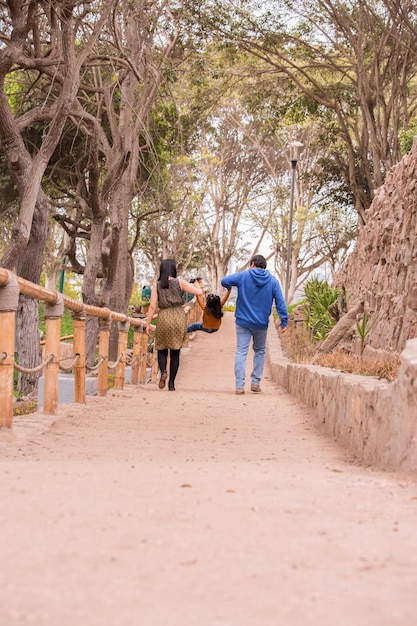 Famiglia che cammina tenendosi per mano in un parco in Perù