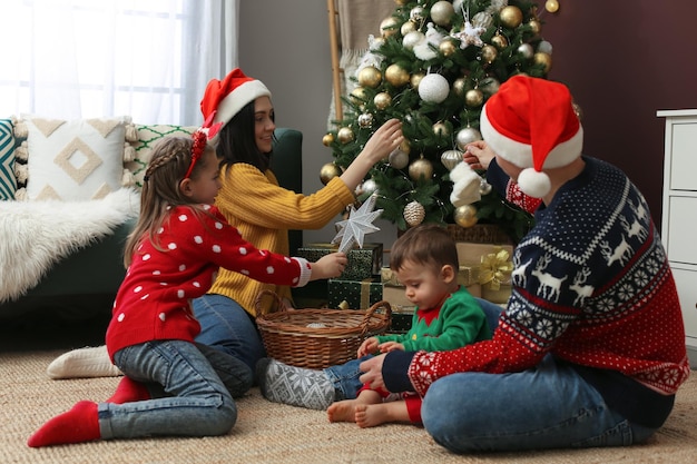 Famiglia che decora il bellissimo albero di Natale a casa