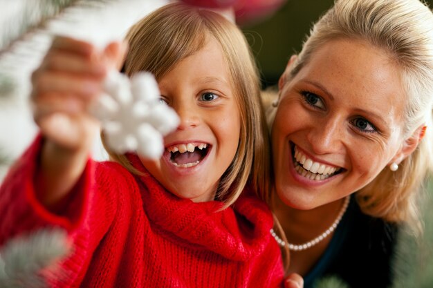 Famiglia che decora l'albero di Natale