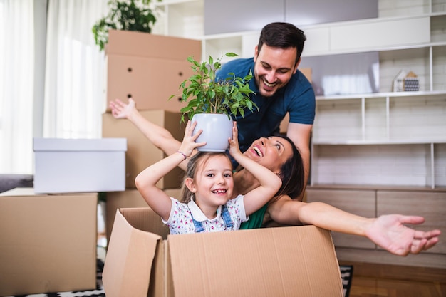 Famiglia che disimballa scatole di cartone nella nuova casa.