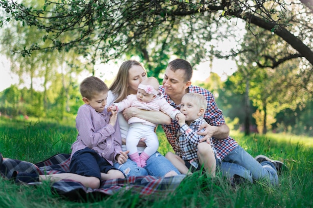 Famiglia che fa picnic in campagna Concetto candida famiglia felice e tre figli