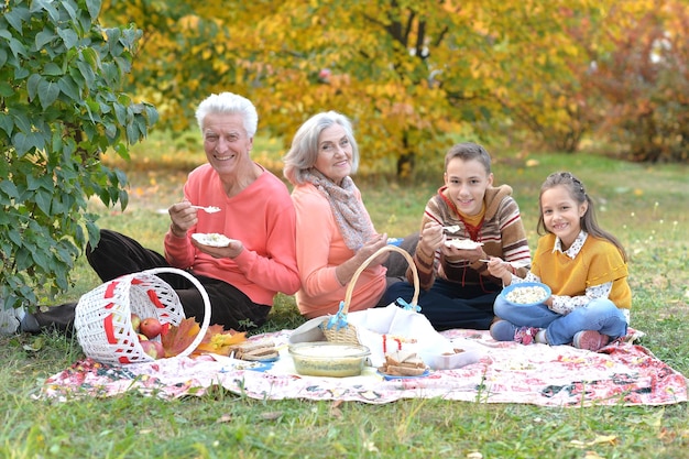 Famiglia che fa un picnic nel parco in autunno