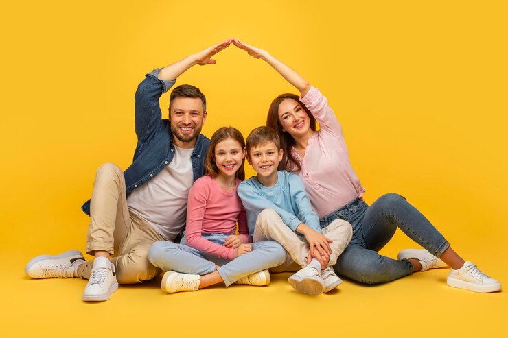 Foto famiglia che forma un tetto di casa con le mani sul giallo