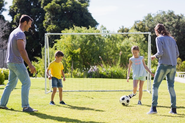 Famiglia che gioca a calcio insieme al parco