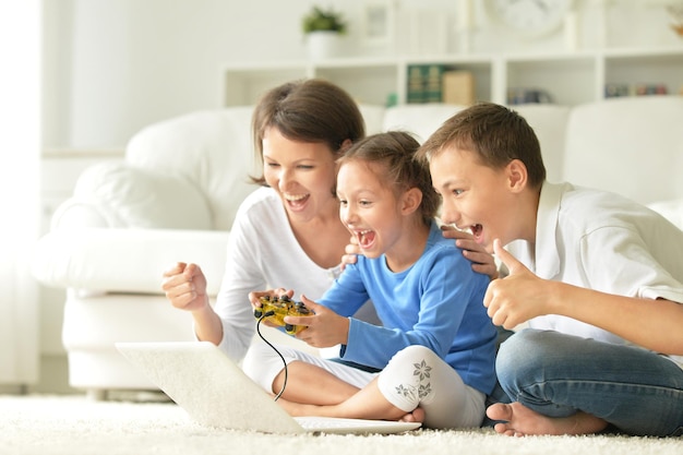 Famiglia che gioca al computer, madre con bambini