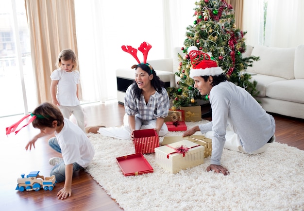 Famiglia che gioca con i regali di Natale a casa