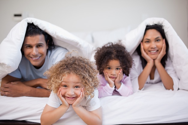 Famiglia che gioca insieme in camera da letto