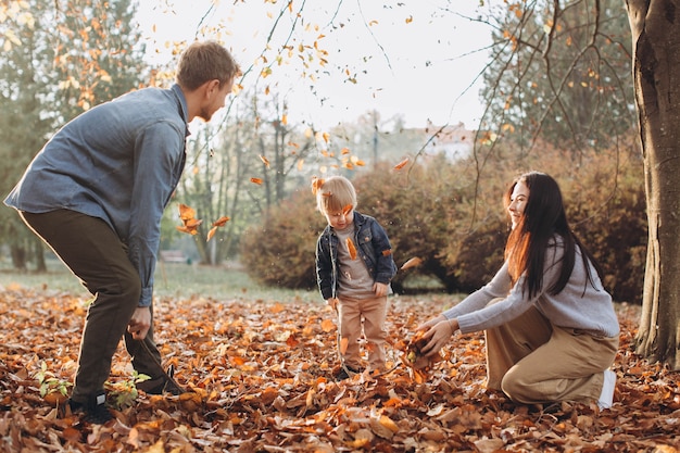 Famiglia che gioca nella sosta di autunno divertendosi