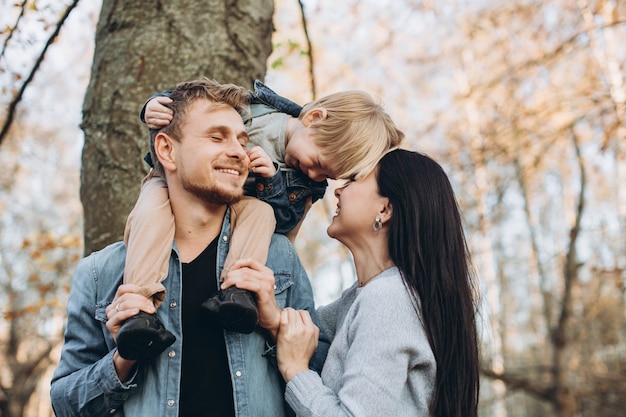 Famiglia che gioca nella sosta di autunno divertendosi