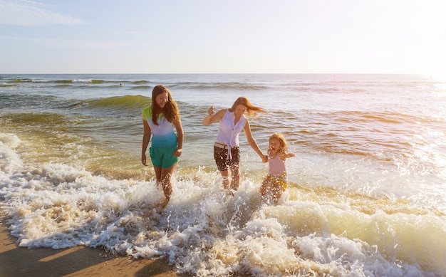 Famiglia che gioca sulla riva dell'oceano.