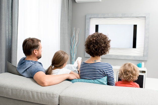 Famiglia che guarda la TV in salotto